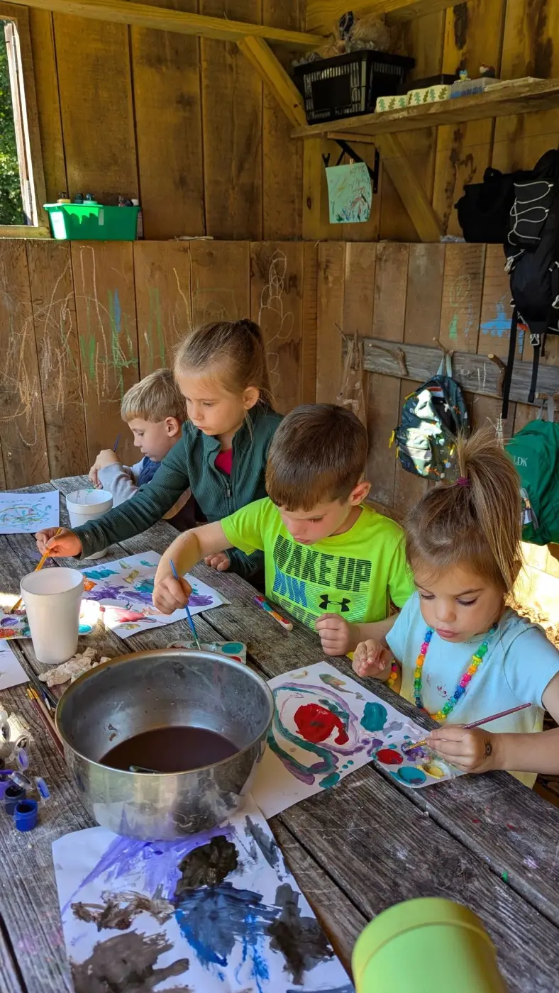 Four children painting enthusiastically at a rustic wooden table in a cozy cabin.